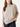 Woman wearing a beige sweater on a white background