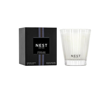 Nest New York’s Cedar Leaf & Lavender Collection Candle and Packaging. Candle features Nest’s signature etched glass candle holder and black packaging with purple stripe.