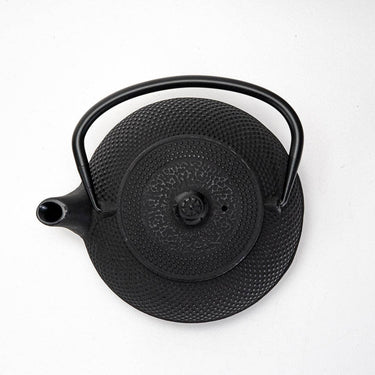 Black cast iron teapot on a white background