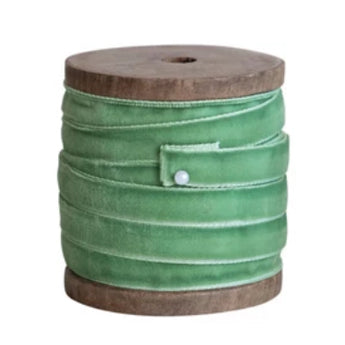 Wooden spool with spring green velvet ribbon secured with pin