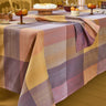 Checkered tablecloth on a dining table with various dishes and decor.