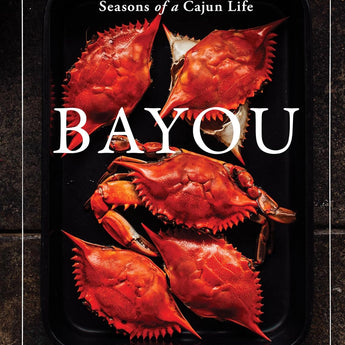 Book cover features a dark background with a white border design. There are five vivid orangey red cooked crabs scattered on a black sheet pan