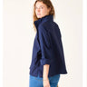 Woman wearing a navy blue jacket and blue jeans on a white background