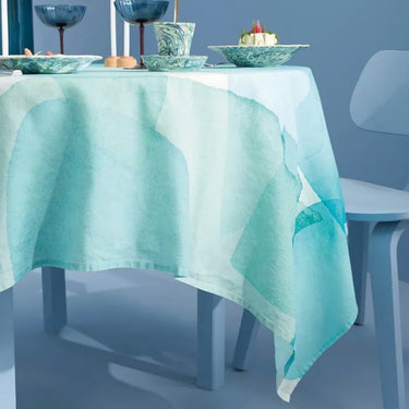 Tablecloth with a geometric pattern on a table against a blue wall.