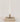 Hand-Forged Iron Bow Shaped Taper Holder, Antique Gold Finish Shown with lit candle in a vignette on a stack of books.