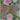 Floral pattern with pink, purple, and red flowers on a green background