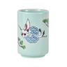 Light blue ceramic cup with bird and wave design on a white background