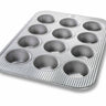 Metal muffin tin with multiple compartments on a white background
