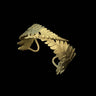 Gold leaf-shaped earring on a black background